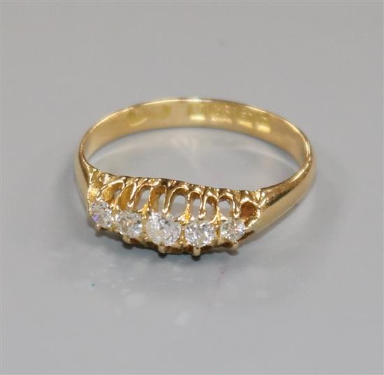 An early 20th century 18ct gold and graduated five stone diamond half hoop ring, size M.